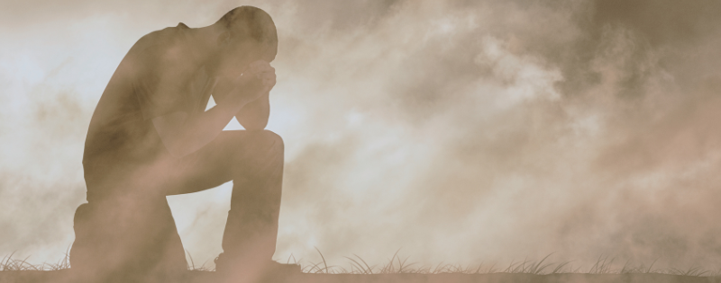Person sitting contemplatively representing the tension between faith and doubt, holding both pain and God's promises
