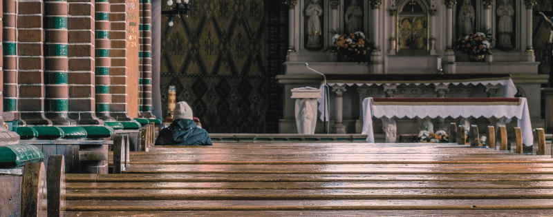 Person sitting in empty church pew contemplating when to leave a church