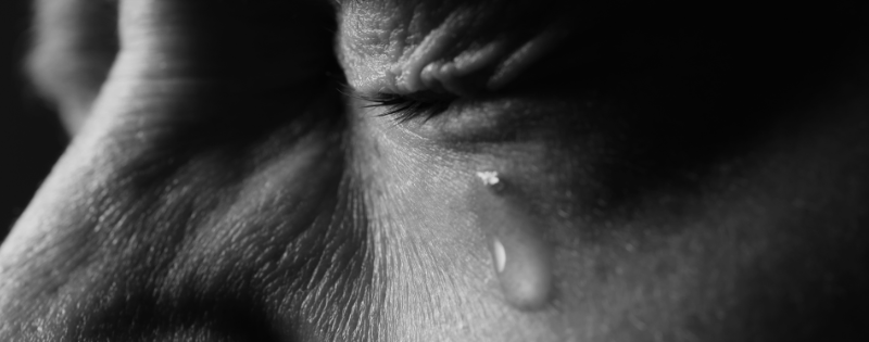 Woman sitting alone in grief, illustrating Romans 8:28 and the misuse of "all things work together for good" in fresh tragedy