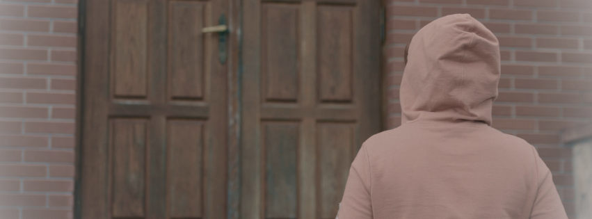 Person standing outside church doors hesitating, feeling judged at church before walking in